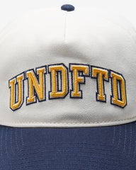 UNDEFEATED 2-TONE ARCH SNAPBACK - IVORY/ NAVY
